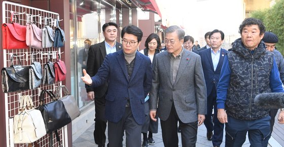 문재인 대통령(가운데)이 3일 서울 성동구 성수 수제화 희망플렛폼을 방문해 유홍식 드림제화 대표(오른쪽), 정원호 성동구청장과 수제화 거리를 돌아보며 설명을 듣고 있다. [청와대사진기자단]