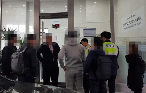 13일 오전 10시 30분 서울 강남구 테헤란로에 위치한 가상화폐 거래소 ‘빗썸’ 본사 1층 문 앞에서 사설 경호업체 직원(왼쪽에서 세번째)과 투자자들이 대치하고 있다. 오른쪽 벽에는 전날 가격이 100만원 이상 급등락한 비트캐시 홍보 현수막이 붙어있다./사진=이민아 기자